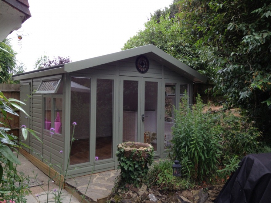 12 x 12 contemporary Merlin garden room painted in 'Jungle Green' and looking perfect in its surroundings