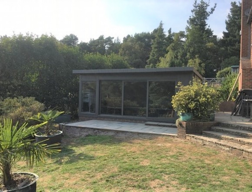 The stunning tri-sliding door endless pool room sits beautifully within the clients garden