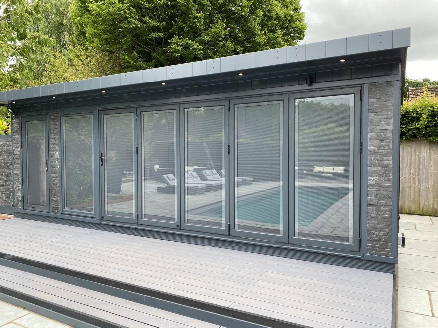 Bi-fold room with antisun-gray reflective glass, integrated blinds and Slate splitface stone cladding