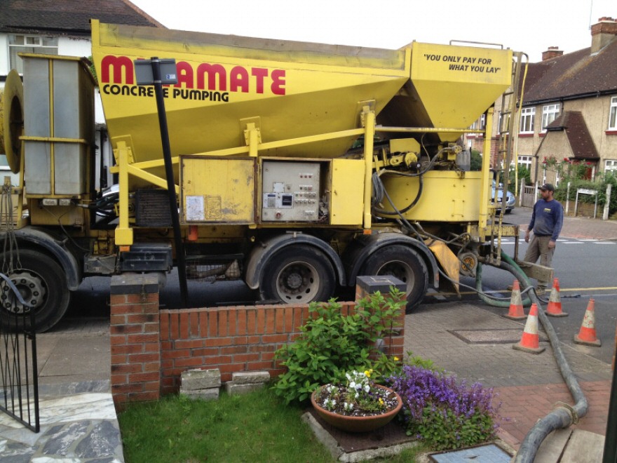 Concrete being pumped from lorry at front of house to rear garden