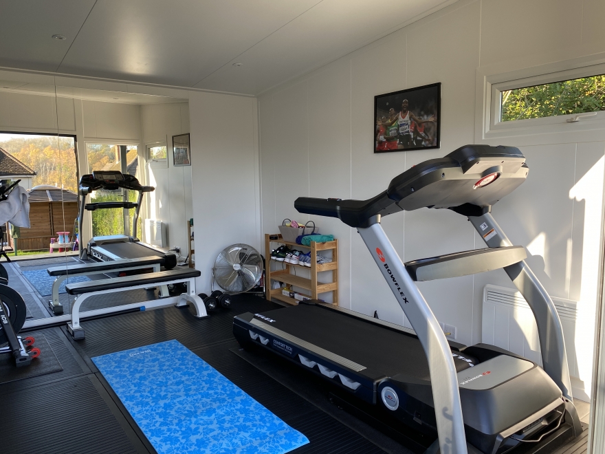 Garden room being used as a gym with treadmill, yoga area and weights