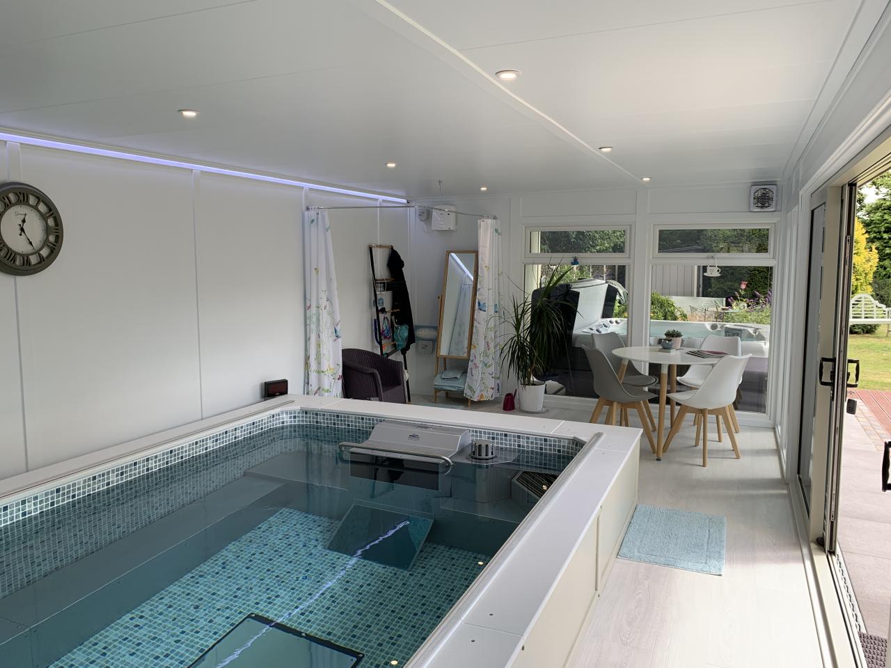 This Endless pool room with side canopy for a Hot-tub offers so much for the user, beautifully finished with some great features throughout. 
In the client's words:
Finding a suitable building to house an Endless Pool had proved very difficult, until we came across Bakers and visited their show buildings at Haywards Heath.
Martin Baker showed us round and explained the pros and cons of all the buildings and options - no hard sell, just a pleasant chat.
We were sold and haven't been disappointed with the resulting build and building.
Lovely people, great product. Highly Recommended